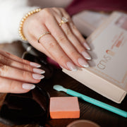 CNVS Nails Medium Pink French Almond nail on hand reaching into purse for nail box and accessories

