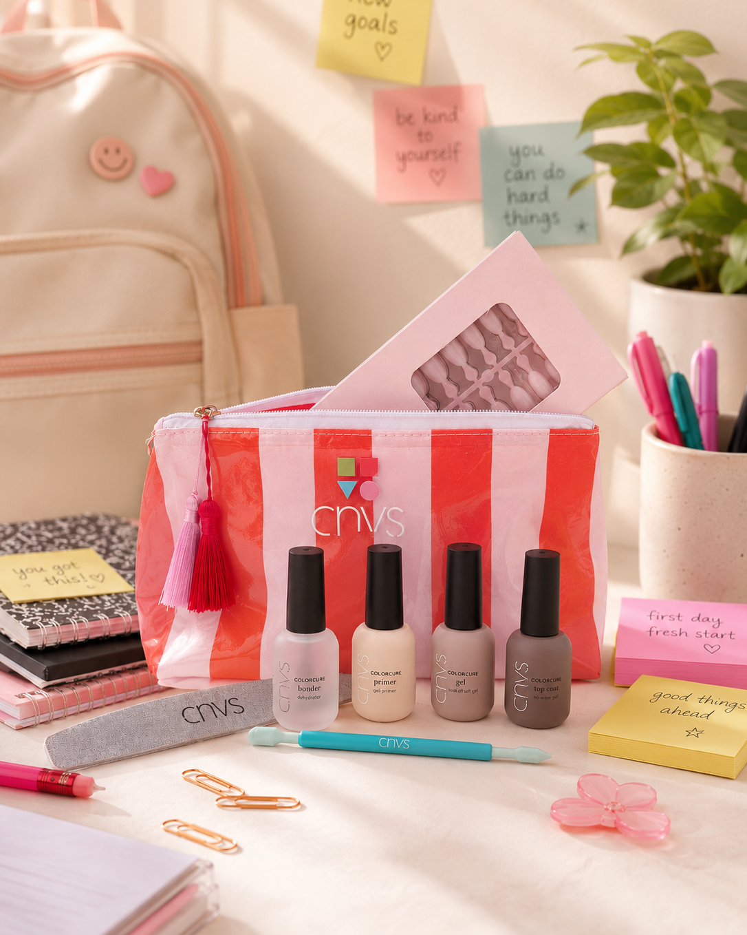 A pink and white striped CHVS nail care set displayed on a desk with school and office props, including a backpack, sticky notes, a plant, and pens.