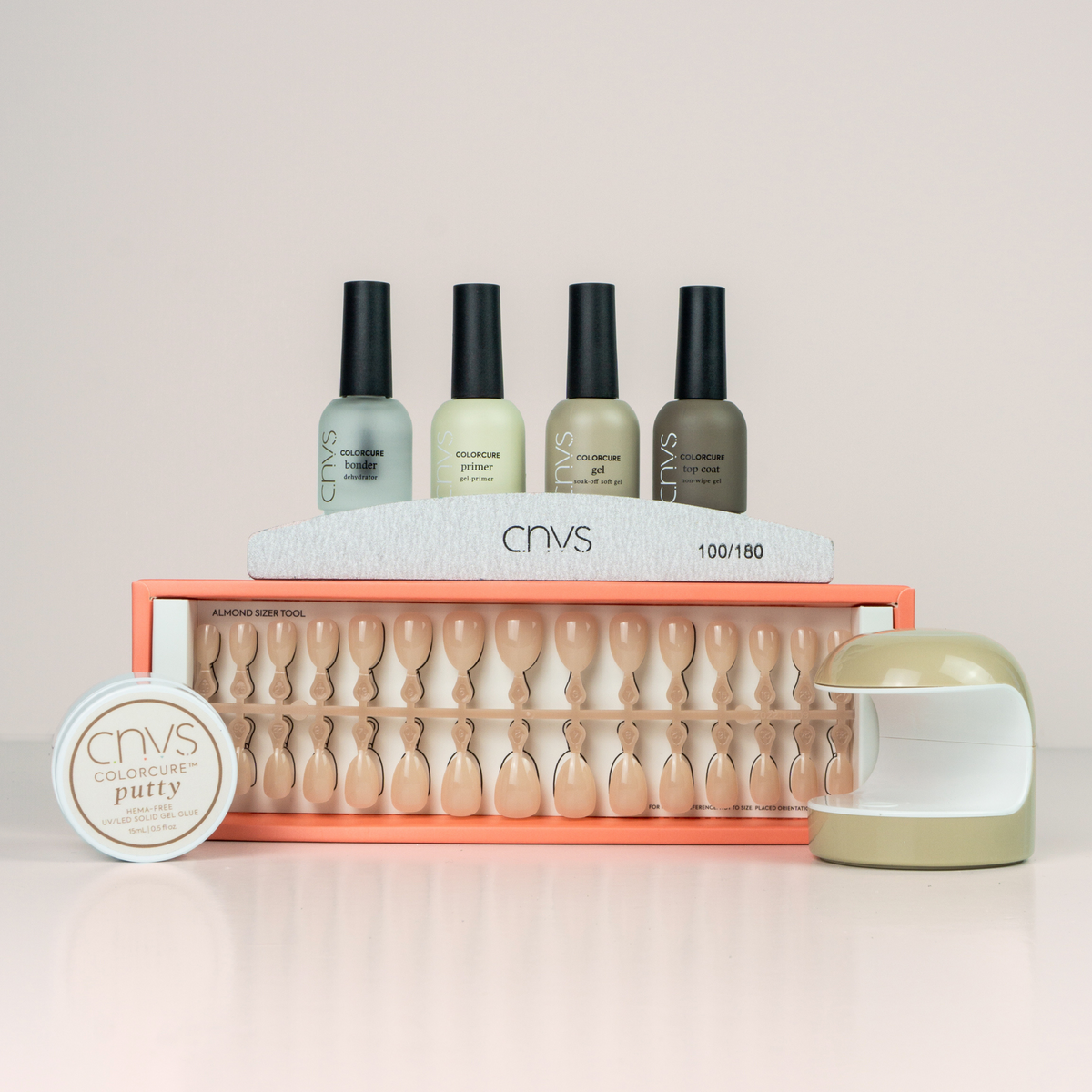 Quick Start Bundle with short nude almond nails and application supplies for at-home manicures by CNVS Nails