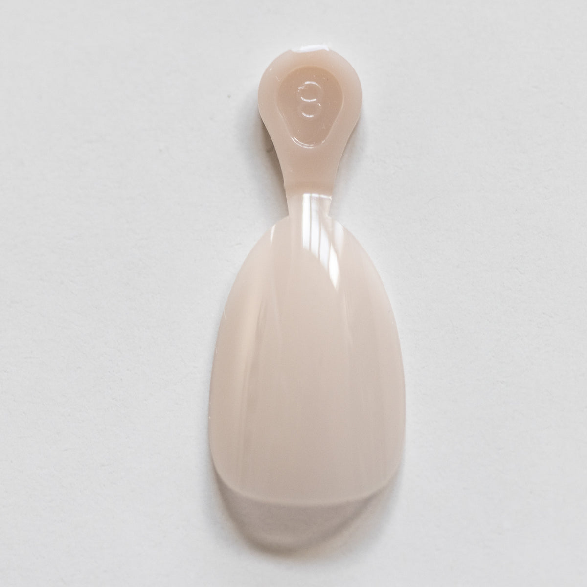 Single usable short nude almond gel nail extension for at-home manicures by CNVS Nails. Used to build a custom-fit manicure set