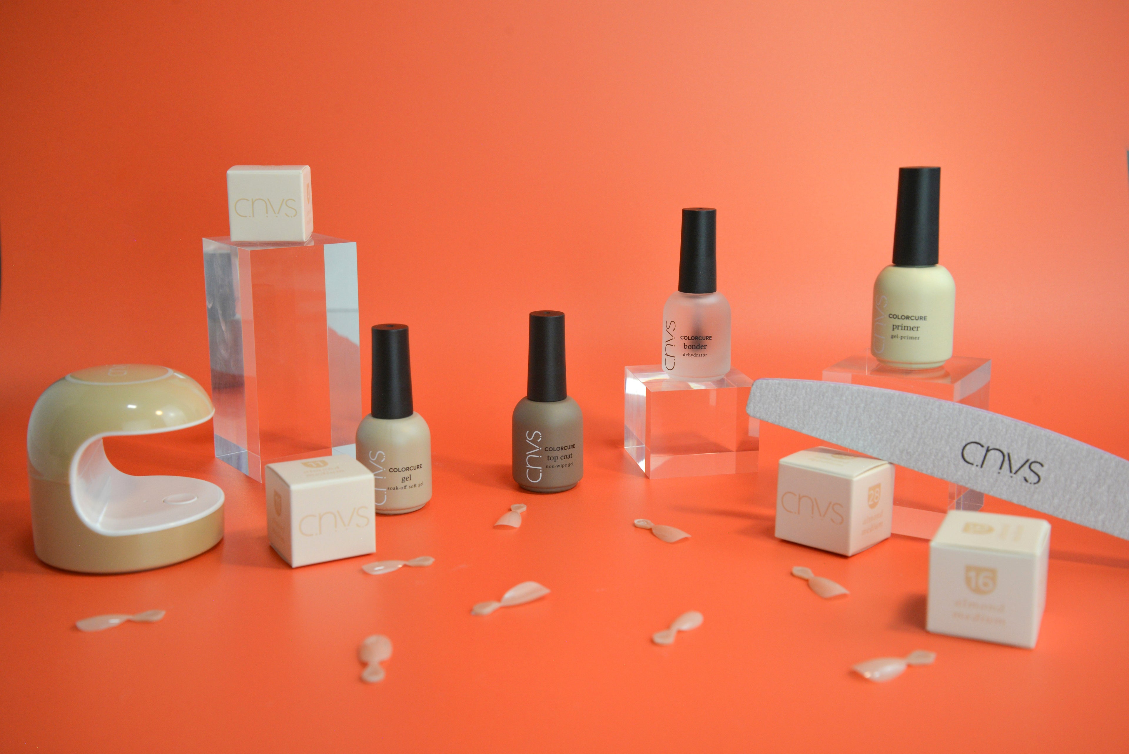 Nail polish bottles and accessories on an orange background with 'CIVIS' branding.